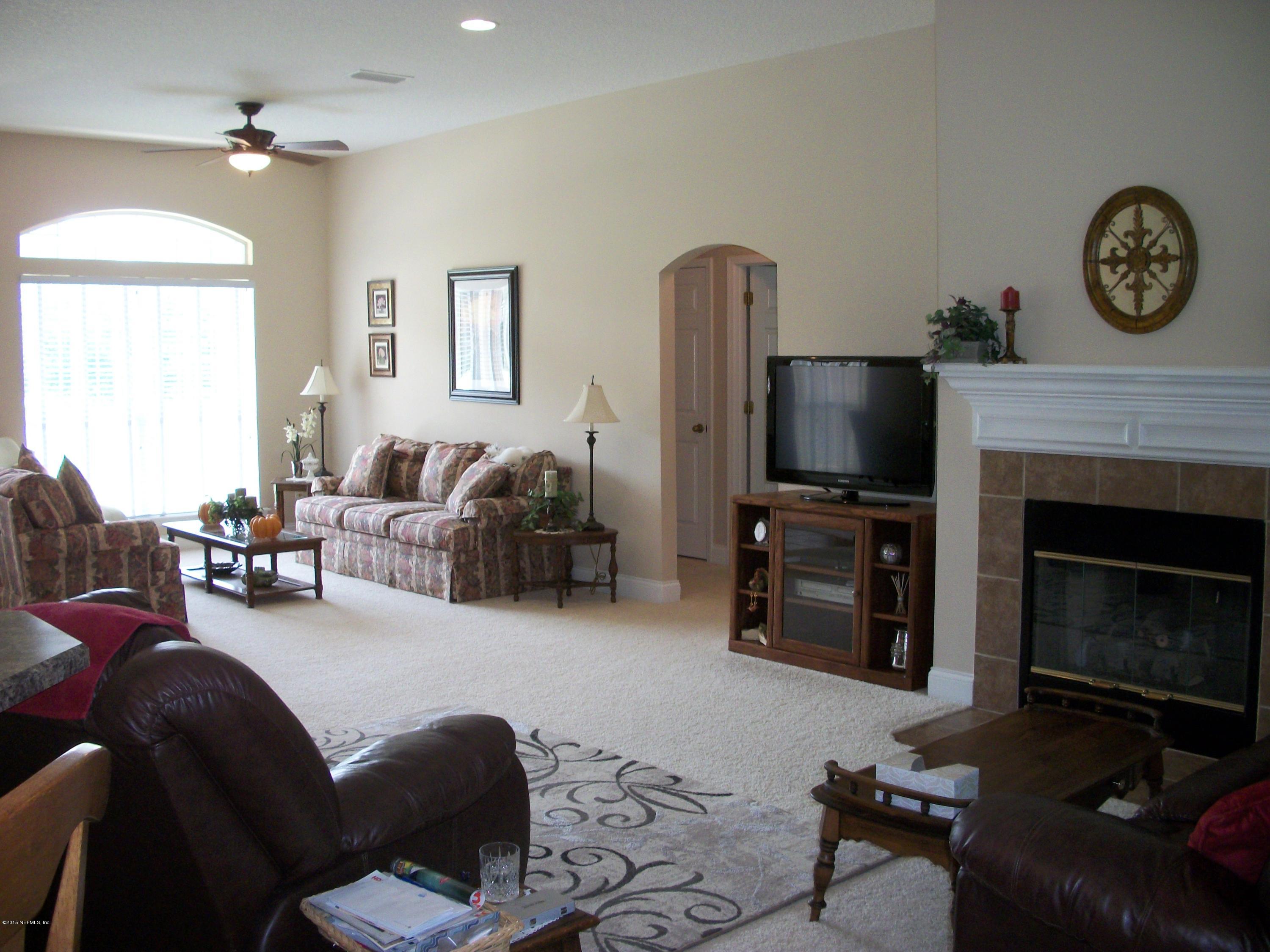 96057 Maranatha Road Yulee, FL 32097 - Photo 5 of 25 a living room with furniture a flat screen tv and a fireplace