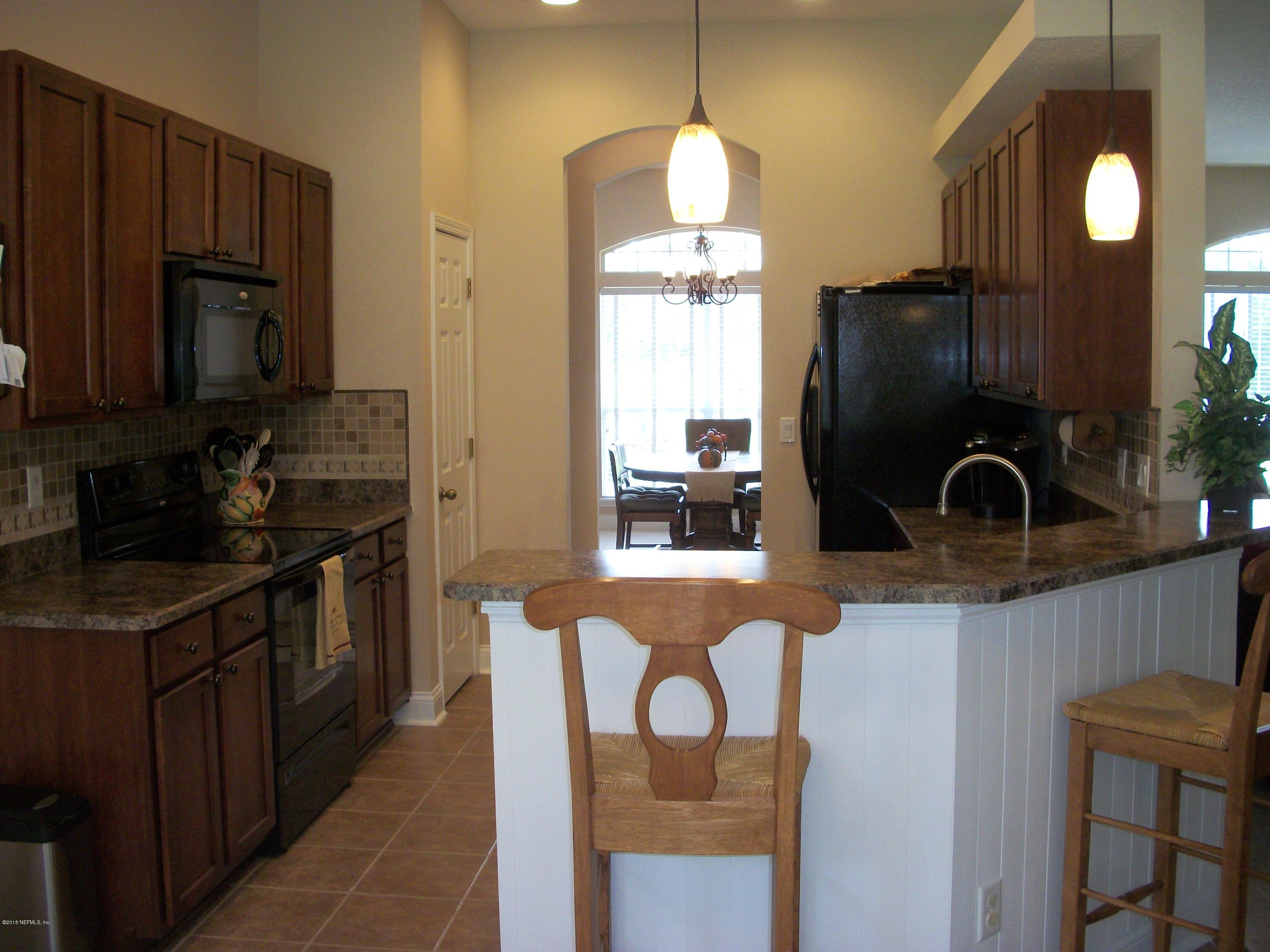 96057 Maranatha Road Yulee, FL 32097 - Photo 7 of 25 a kitchen with granite countertop a sink a stove and refrigerator