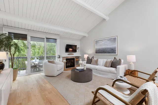 a living room with furniture a large window and a flat screen tv