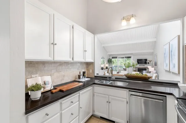 a kitchen with white cabinets and sink