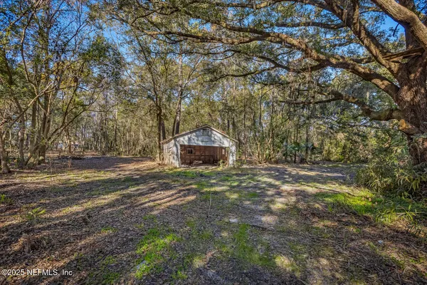 a backyard of a house with trees and outdoor seating