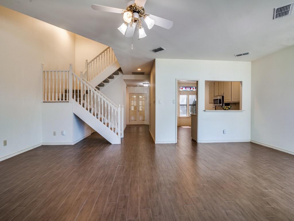 9959 Waterfront Trail Rowlett, TX 75087 - Photo 9 of 26 Unfurnished living room featuring ceiling fan, dark wood-style floors, and stairs