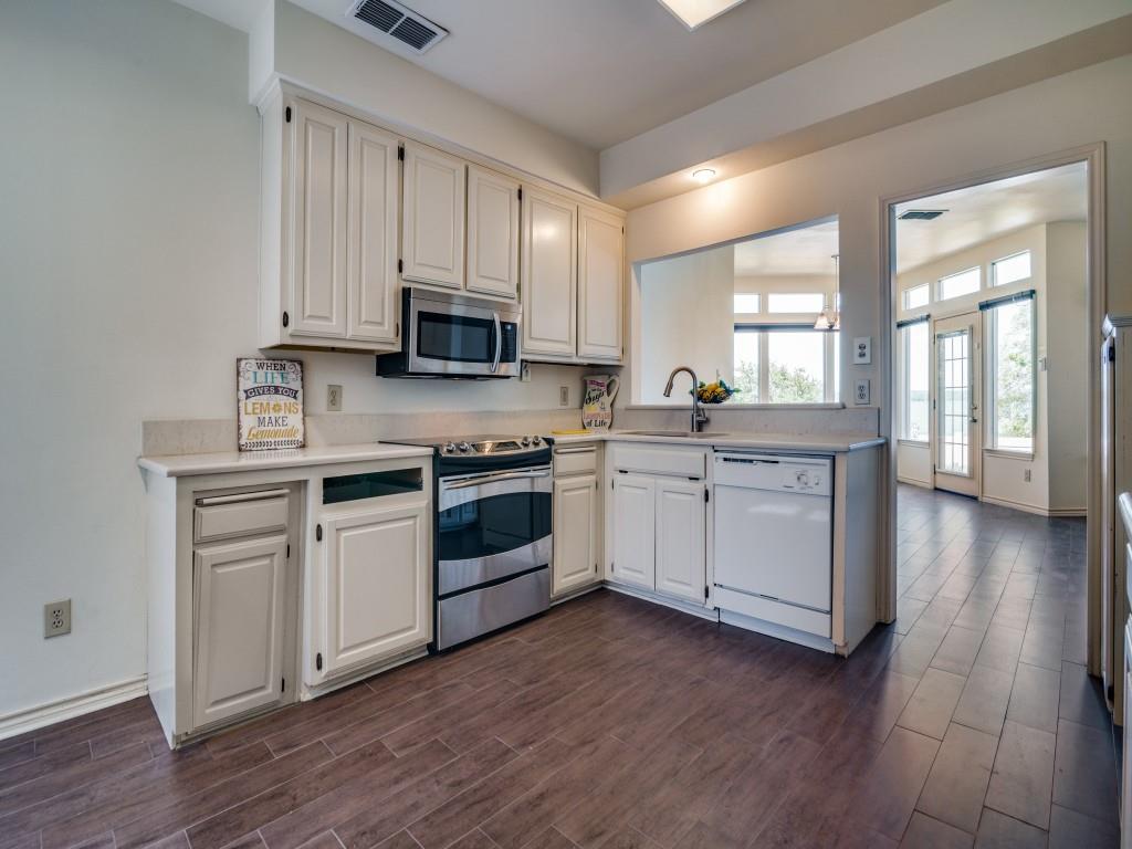9959 Waterfront Trail Rowlett, TX 75087 - Photo 10 of 26 a kitchen with a white cabinets and wooden floor