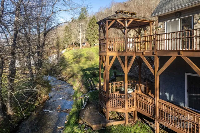 a view of a brick house with large windows and a small yard