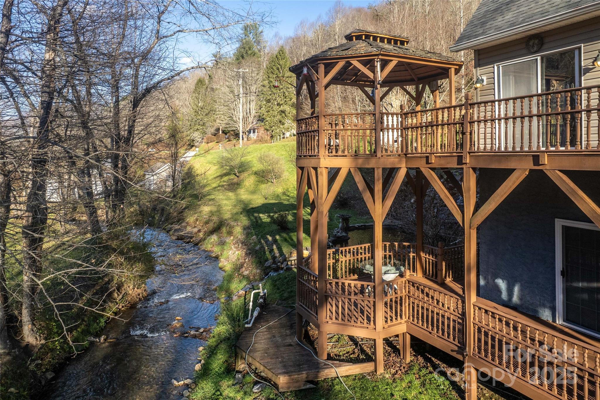 814 Barkers Creek Road Whittier, NC 28789 - Photo 10 of 40 a view of a brick house with large windows and a small yard