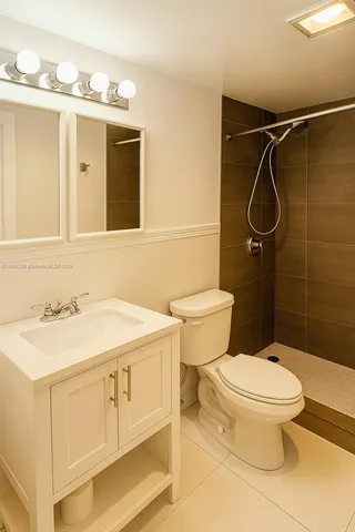 a bathroom with a sink vanity mirror and toilet