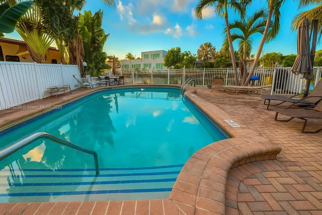 a view of a swimming pool with a yard and plants