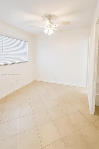 en empty room with white walls and tiles