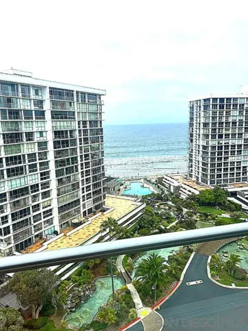 a view of a balcony with a floor to ceiling window next to a tall building