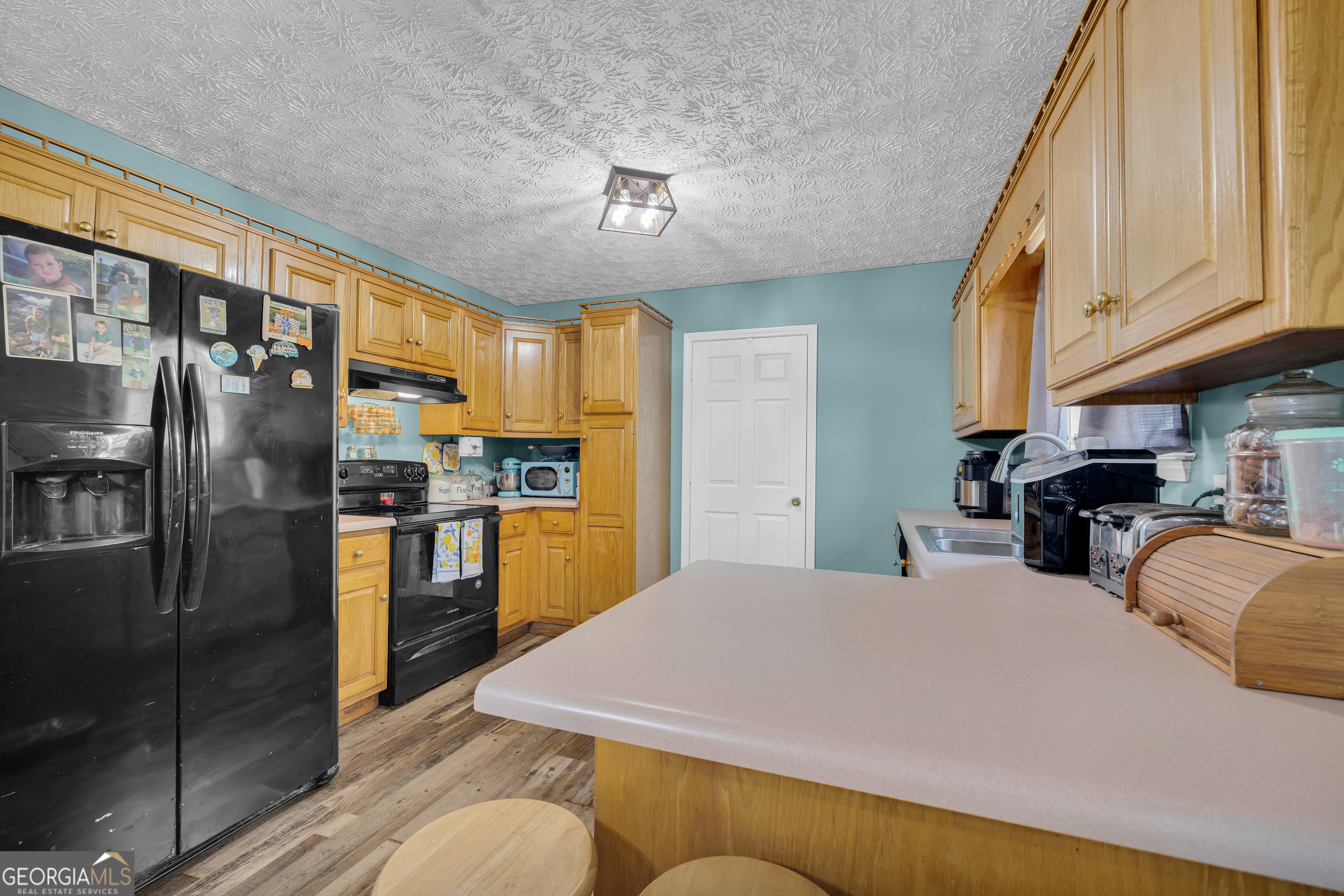 156 Shirley Road Royston, GA 30662 - Photo 9 of 29 a kitchen with stainless steel appliances granite countertop a refrigerator a sink dishwasher a stove and a dining table with wooden floor