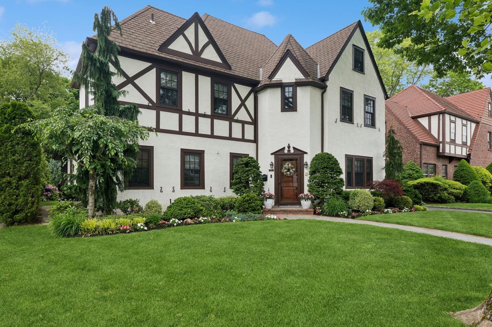 a front view of a house with a garden and plants