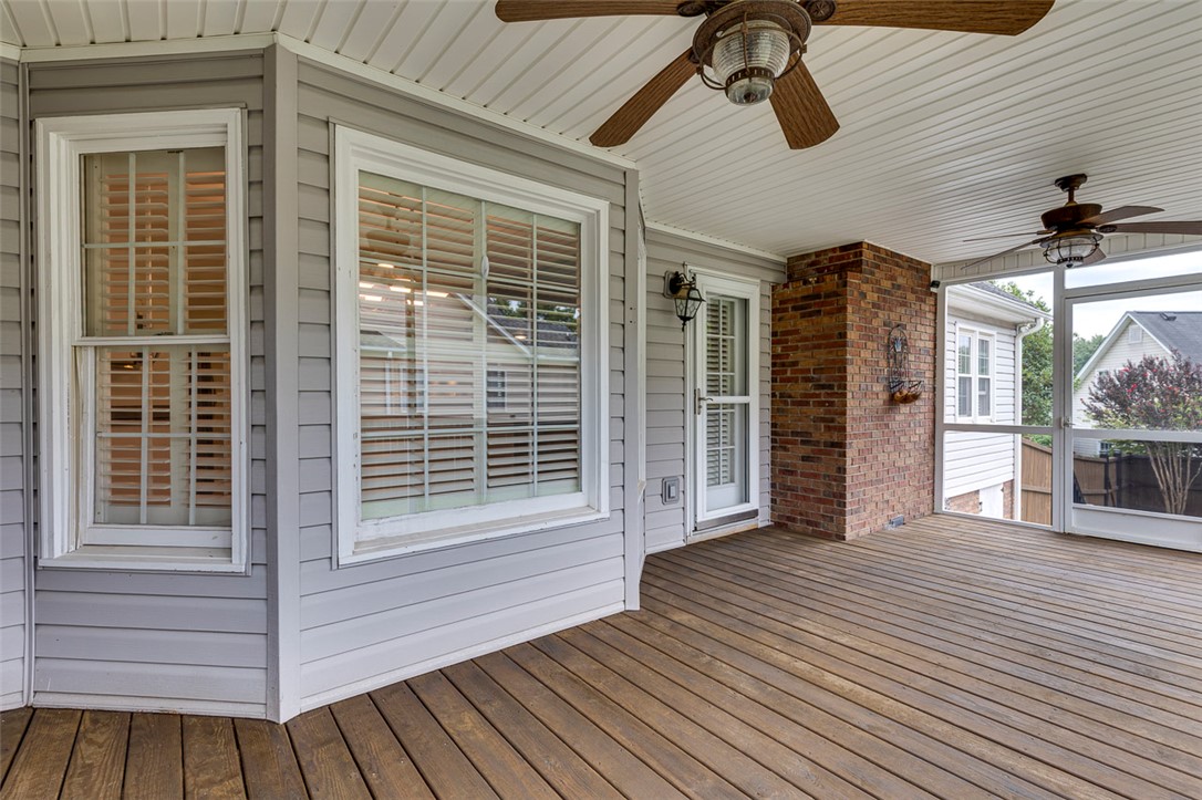 302 Wild Rice Drive Simpsonville, SC 29681 - Photo 36 of 44 An inviting covered deck features wood plank flooring and a classic brick accent wall.