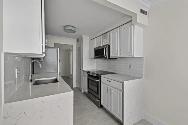 a kitchen with stainless steel appliances granite countertop a sink stove and microwave