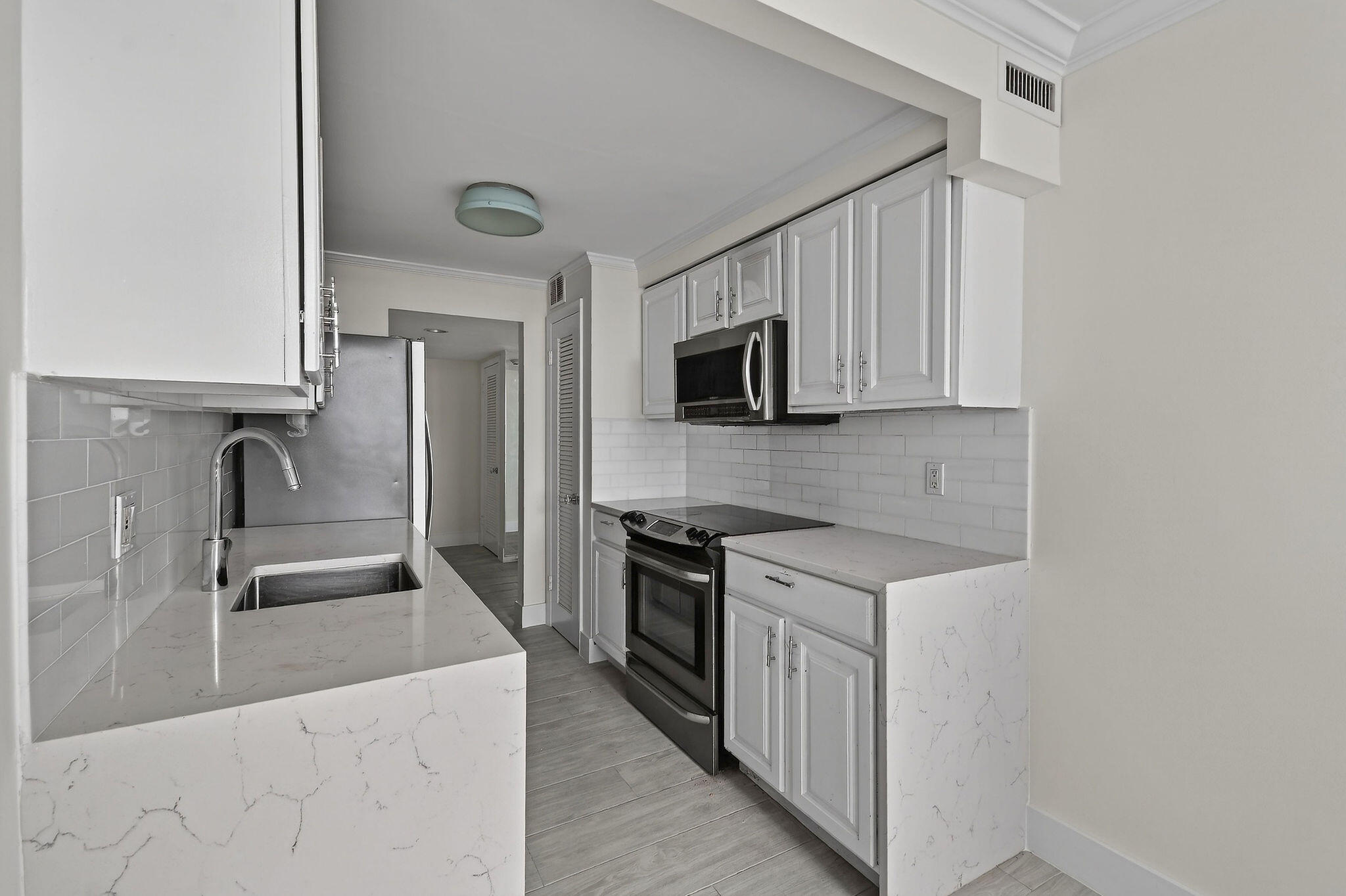 3800 Washington Road, Unit 712 West Palm Beach, FL 33405 - Photo 11 of 48 a kitchen with stainless steel appliances granite countertop a sink stove and microwave