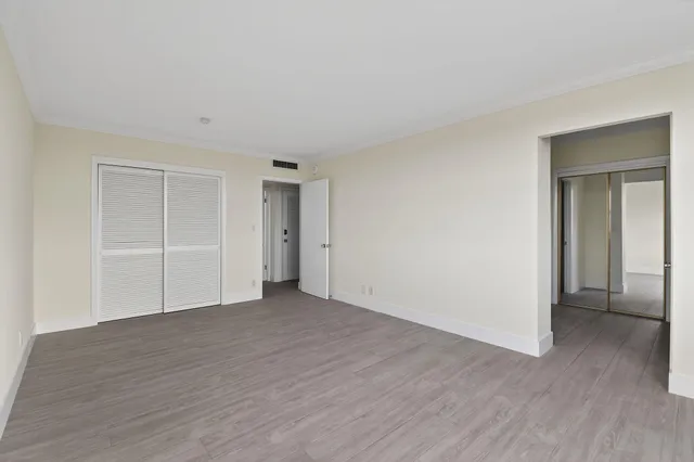 a view of an empty room with wooden floor