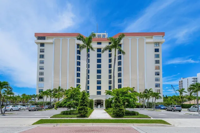 a view of a building with a yard and plants