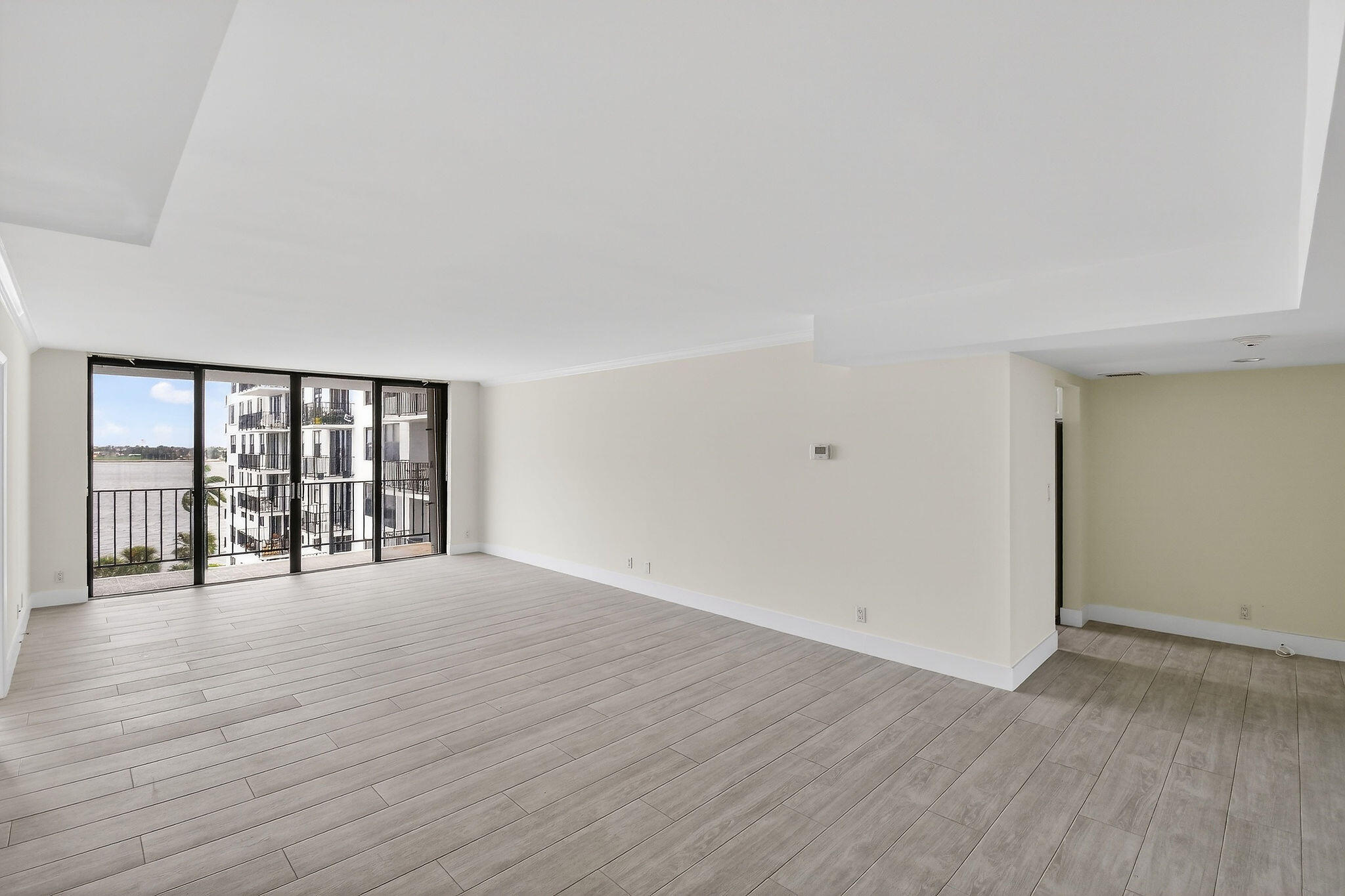 3800 Washington Road, Unit 712 West Palm Beach, FL 33405 - Photo 3 of 48 a view of an empty room with wooden floor and a window