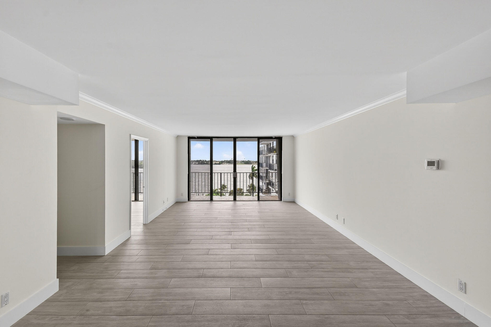 3800 Washington Road, Unit 712 West Palm Beach, FL 33405 - Photo 4 of 48 a view of an empty room with wooden floor and a window