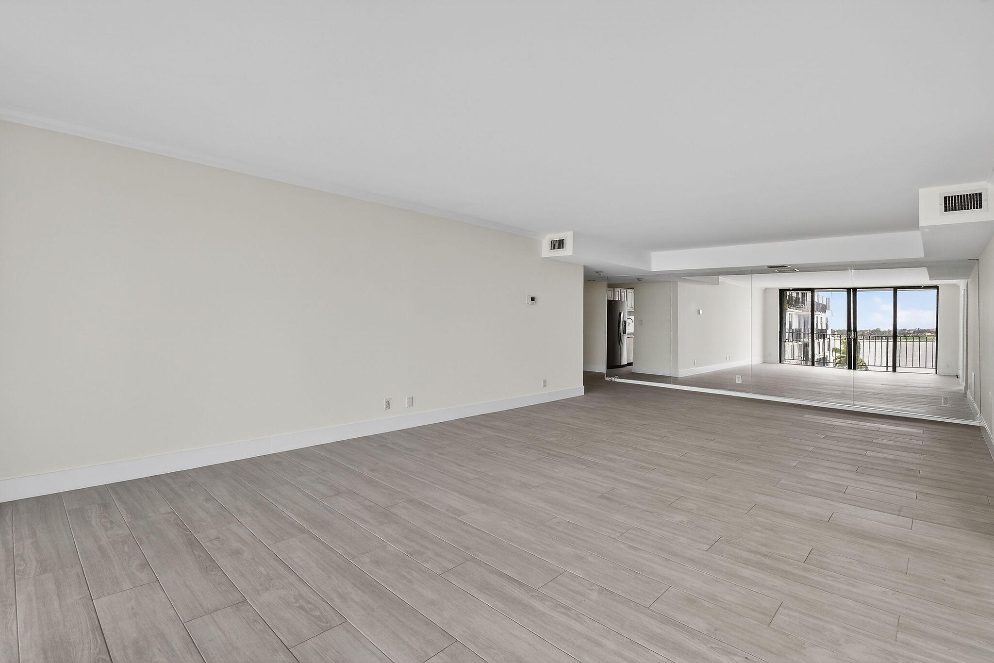 3800 Washington Road, Unit 712 West Palm Beach, FL 33405 - Photo 5 of 48 a view of an empty room with wooden floor and a window