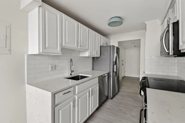 a kitchen with stainless steel appliances granite countertop a sink stove and refrigerator
