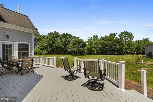 a view of a deck with chairs a barbeque with wooden floor and fence