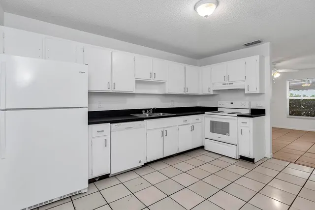 a view of a kitchen with white cabinets