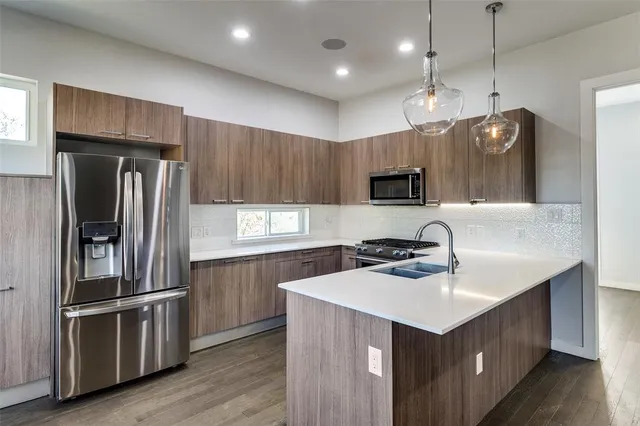 a kitchen with kitchen island a sink stainless steel appliances and cabinets