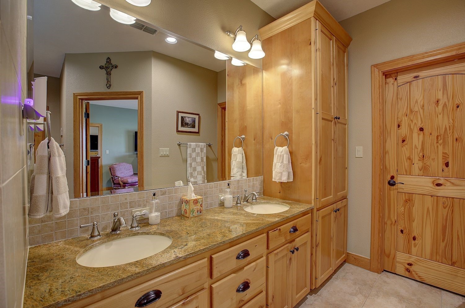 9414 Laird Road Round Top, TX 78954 - Photo 34 of 50 Primary bathroom showing the double sinks and custom cabinetry with one of the walk-in closet doors shown, his/hers walk-ins