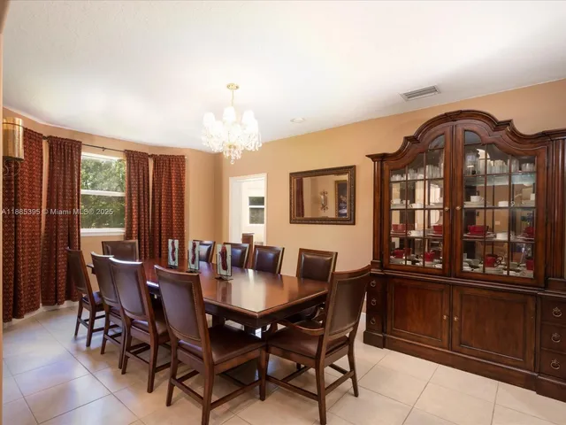 a view of a dining room with furniture a chandelier and wooden floor