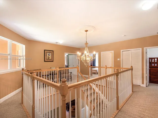 a spacious bedroom with a bed and a chandelier