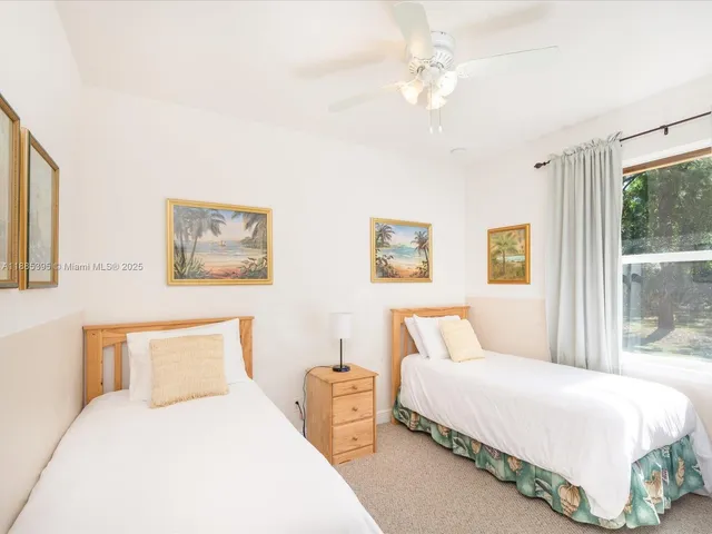 a bedroom with two beds and a chandelier