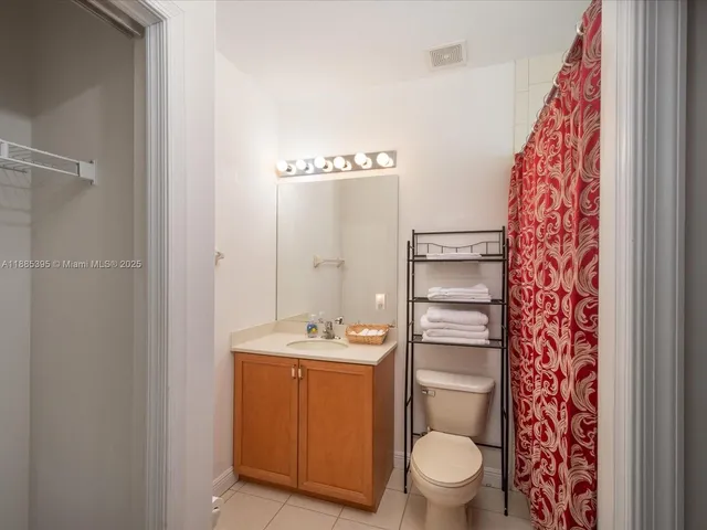 a bathroom with a granite countertop toilet sink and mirror