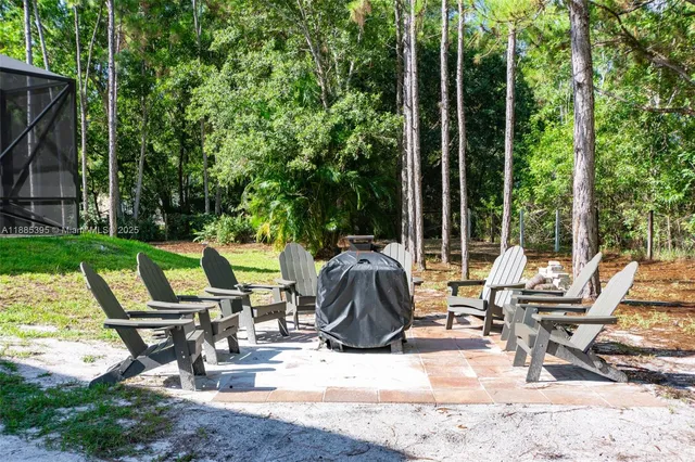 a view of a swimming pool with a yard and large trees