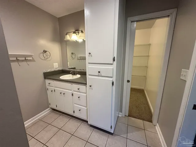 a spacious bathroom with a granite countertop sink and a mirror