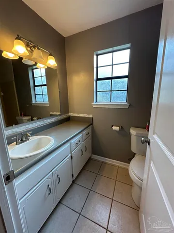 a spacious bathroom with a double vanity sink toilet and a mirror