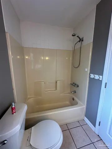 a white toilet sitting next to a bath tub