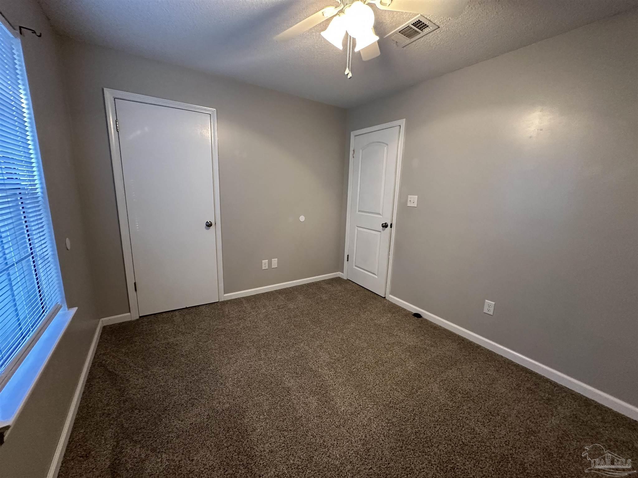 7720 Jansen Road Pensacola, FL 32526 - Photo 29 of 30 an empty room with a chandelier fan and a window
