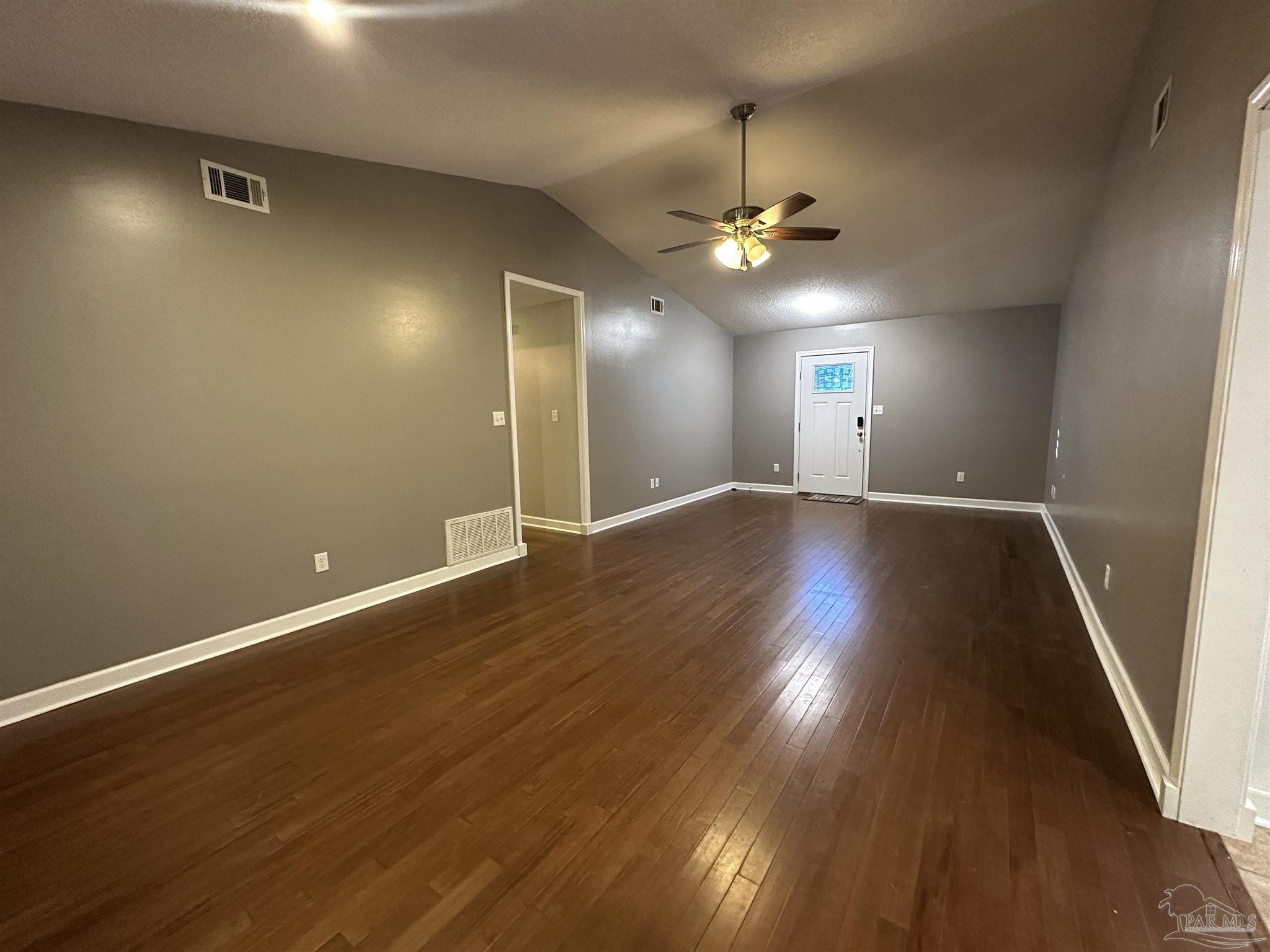 7720 Jansen Road Pensacola, FL 32526 - Photo 5 of 30 an empty room with wooden floor and windows