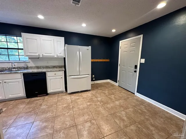 a kitchen with refrigerator cabinets and a sink