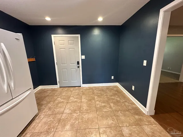a view of hallway with furniture and a refrigerator