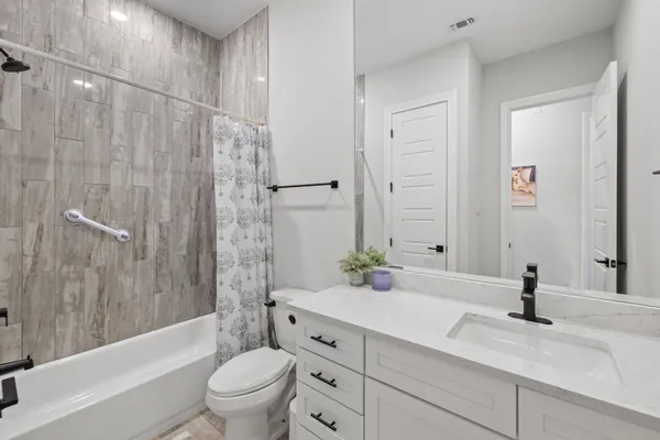 a bathroom with a granite countertop sink a toilet and a bathtub
