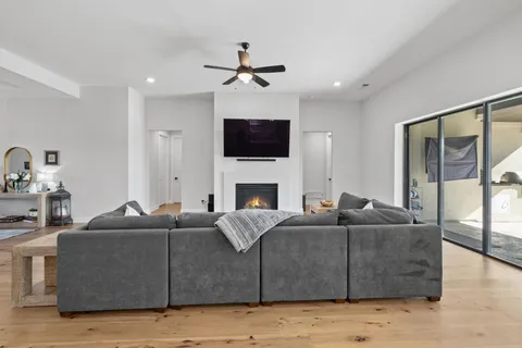 a living room with furniture a flat screen tv and a fireplace
