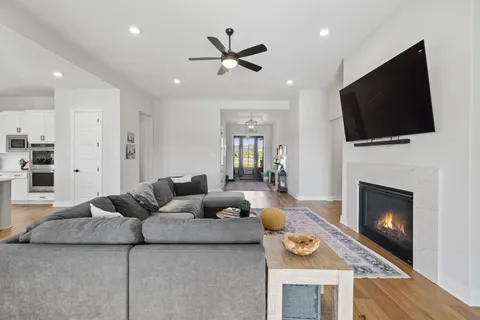 a living room with furniture a flat screen tv and a fireplace