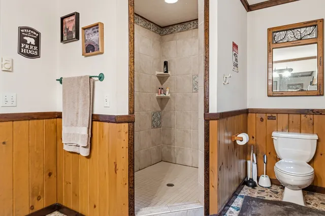 a bedroom with a bed a dresser and a large window