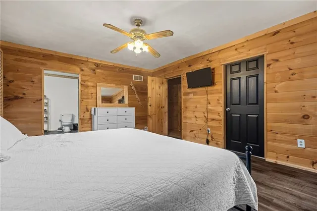 a bedroom with a bed and a large window with wooden floor