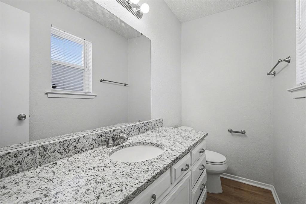 125 Roundtree Street Crowley, TX 76036 - Photo 11 of 25 a bathroom with a granite countertop sink and a toilet