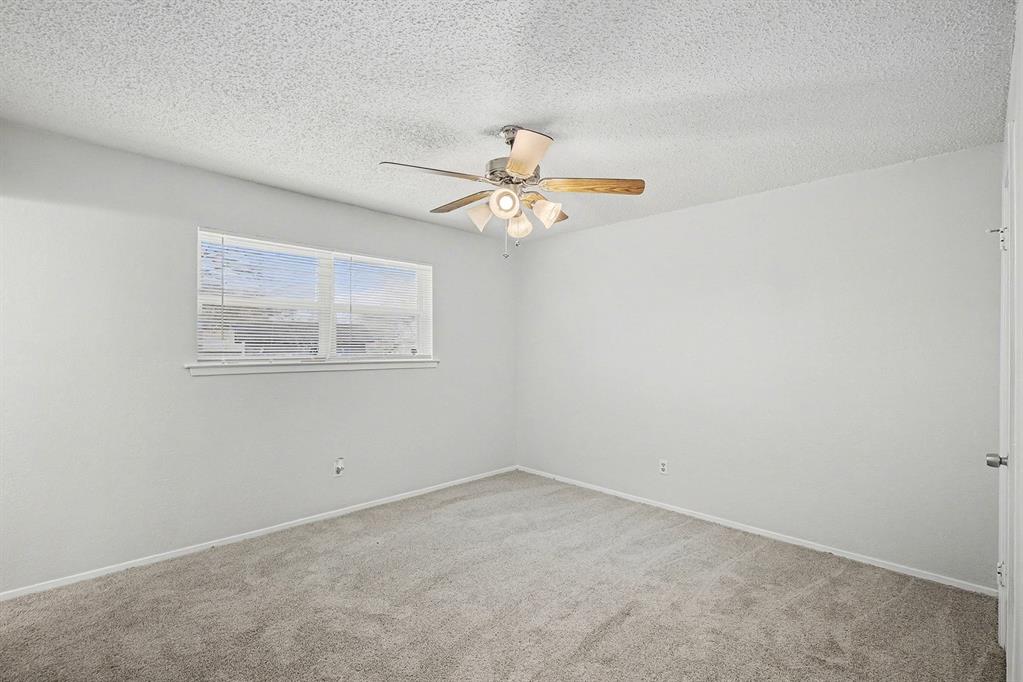 125 Roundtree Street Crowley, TX 76036 - Photo 13 of 25 an empty room with a window and a ceiling fan