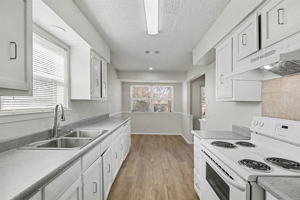 125 Roundtree Street Crowley, TX 76036 - Photo 8 of 25 a kitchen with a sink stove top oven and cabinets