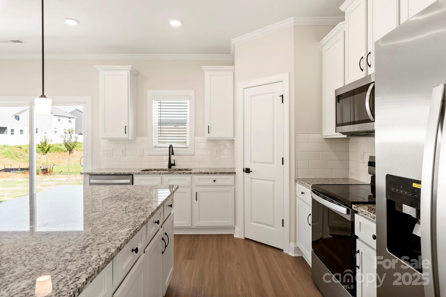 124 Rills Xing Way Troutman, NC 28166 - Photo 13 of 21 a kitchen with stainless steel appliances granite countertop a stove a sink and a refrigerator
