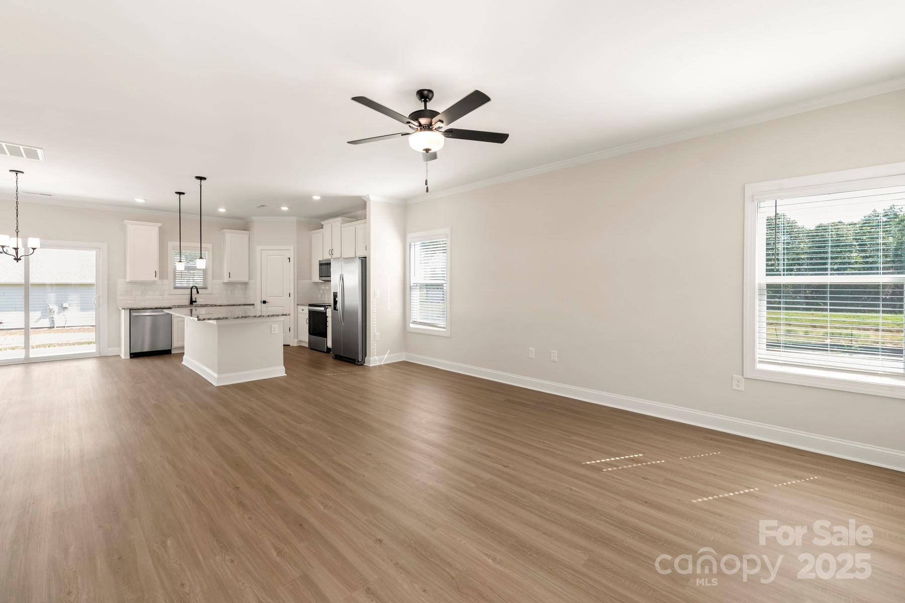 124 Rills Xing Way Troutman, NC 28166 - Photo 9 of 21 a view of a kitchen with a fridge wooden floor and a kitchen